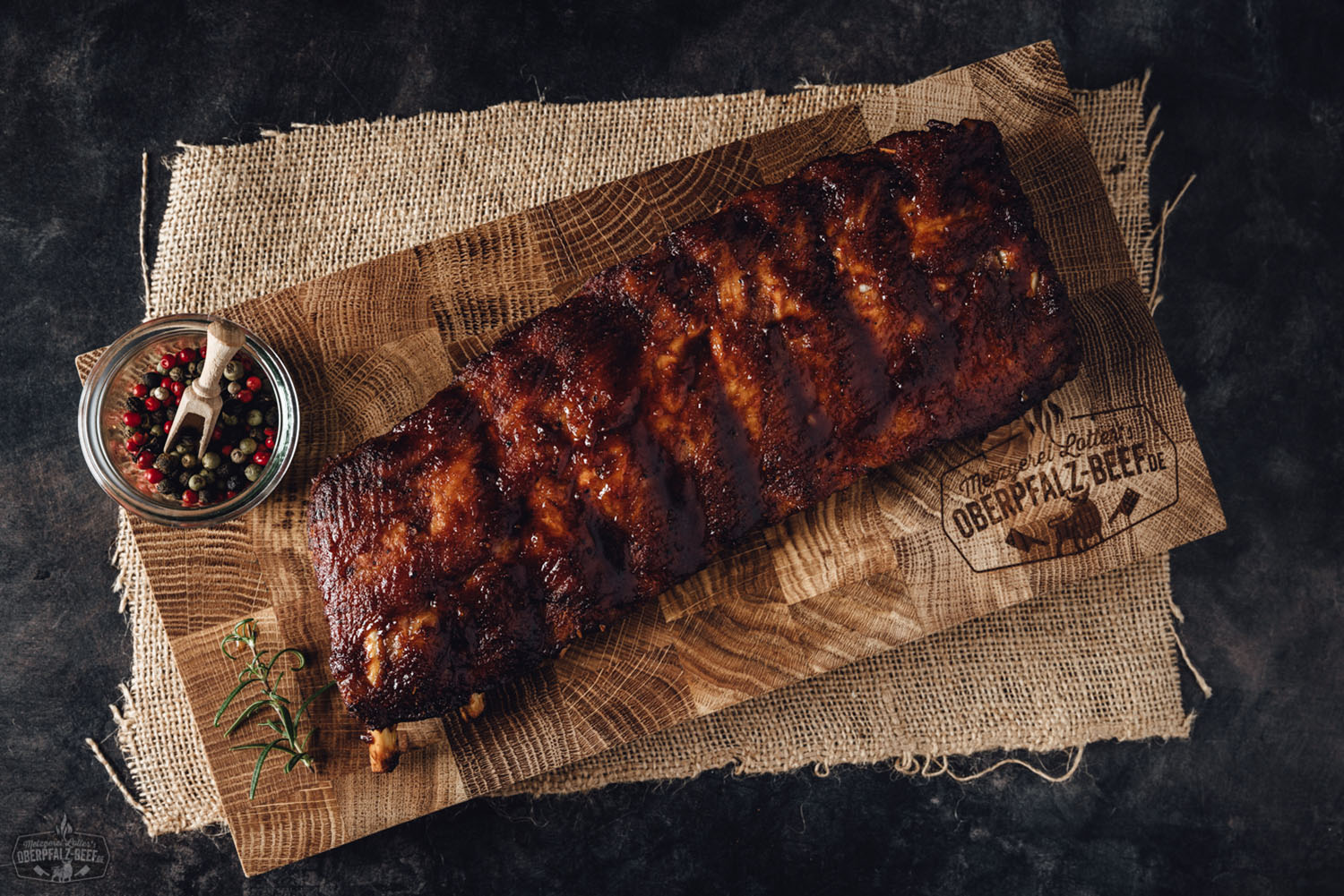 Sous-vide gegarte Baby Back Ribs vom Oberpfälzer Landschwein auf Holzbrett serviert Zart gegarte, glasiert gegrillte Baby Back Ribs vom Oberpfälzer Landschwein, saftig angerichtet auf Holzbrett mit goldbrauner Kruste und rauchigen Röstaromen – hochwertige Sous-vide-Barbecue-Spezialität für Fleischliebhaber.