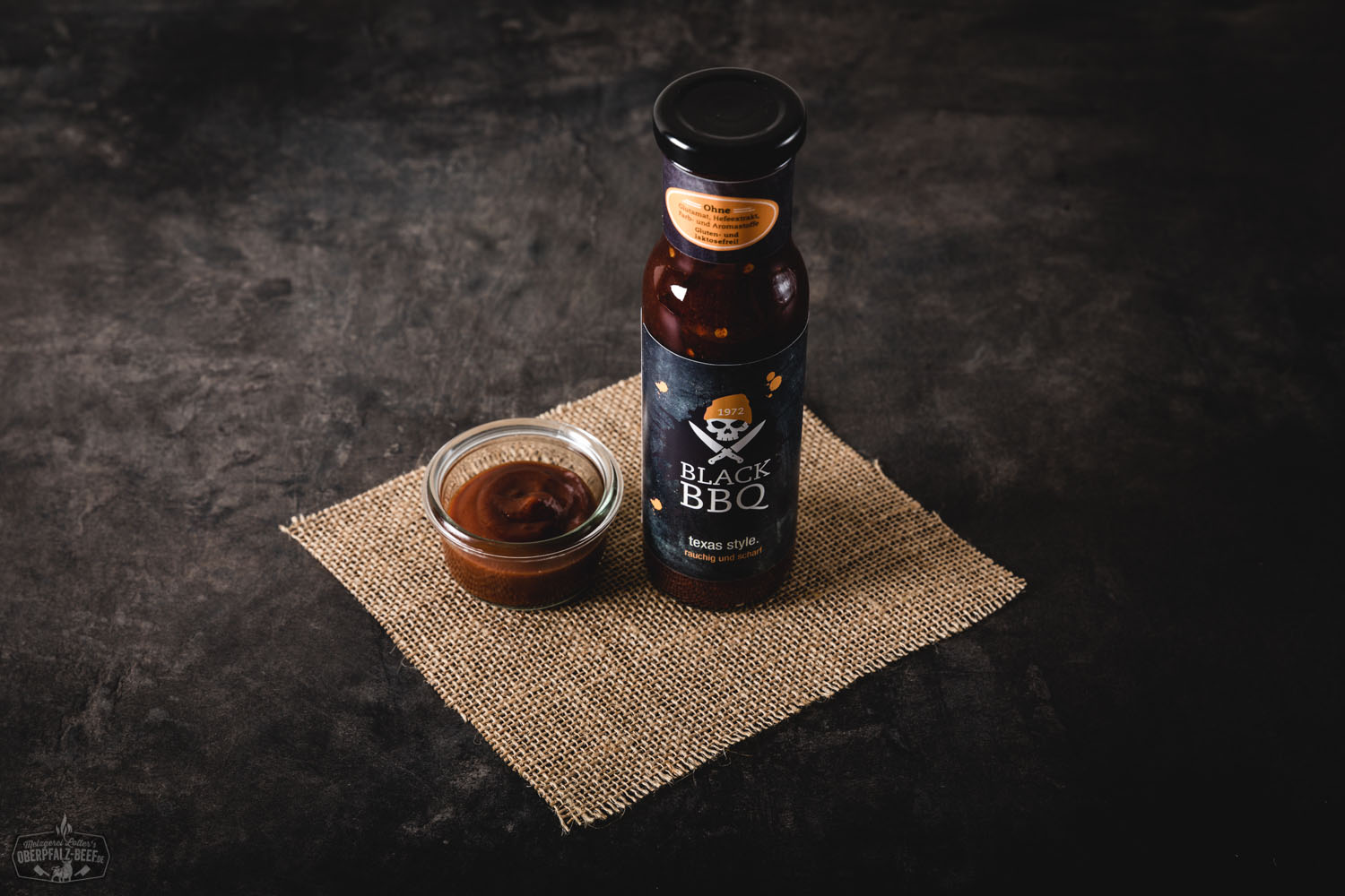 Flasche Black BBQ Soße Texas Style von Oberpfalz Beef auf hellem Untergrund, mit schwarzem Etikett und weißer Schrift – aromatische Barbecue-Sauce im amerikanischen Stil für Grillgerichte.