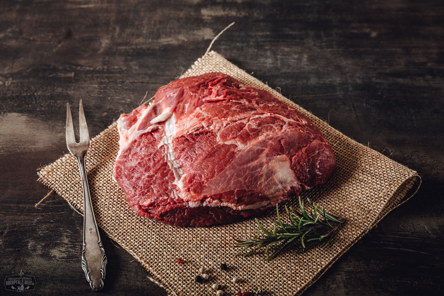Zart geschmorte Kalbsbacken vom Oberpfälzer Milchkalb – regionales Gourmetfleisch kaufen Zart geschmorte Kalbsbäckchen vom Oberpfälzer Milchkalb auf dunkler Soße, angerichtet mit cremigem Kartoffelpüree und glasierten Möhren, serviert auf einem weißen Teller vor dunklem Hintergrund.