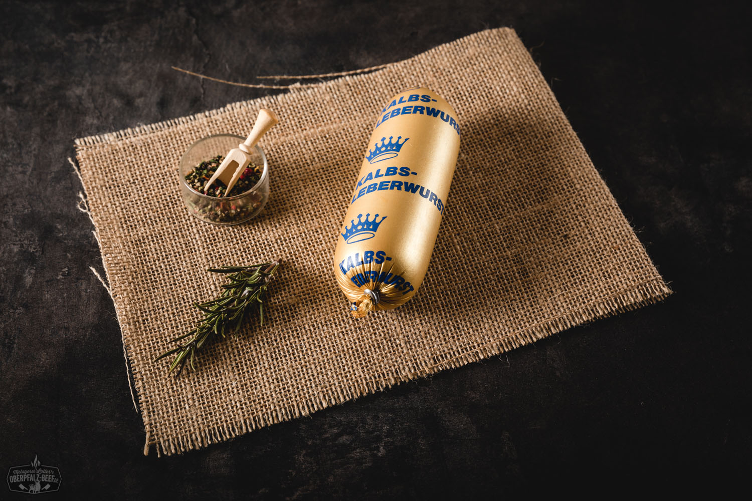 Kalbsleberwurst im Naturdarm – Delikate Portionsgröße aus der Oberpfalz Kalbfleisch-Leberwurst in Portionsgröße – vakuumverpackte, zylindrische Wurst mit heller, glatter Oberfläche, auf weißem Hintergrund liegend; Produkt der Marke Oberpfalz Beef.