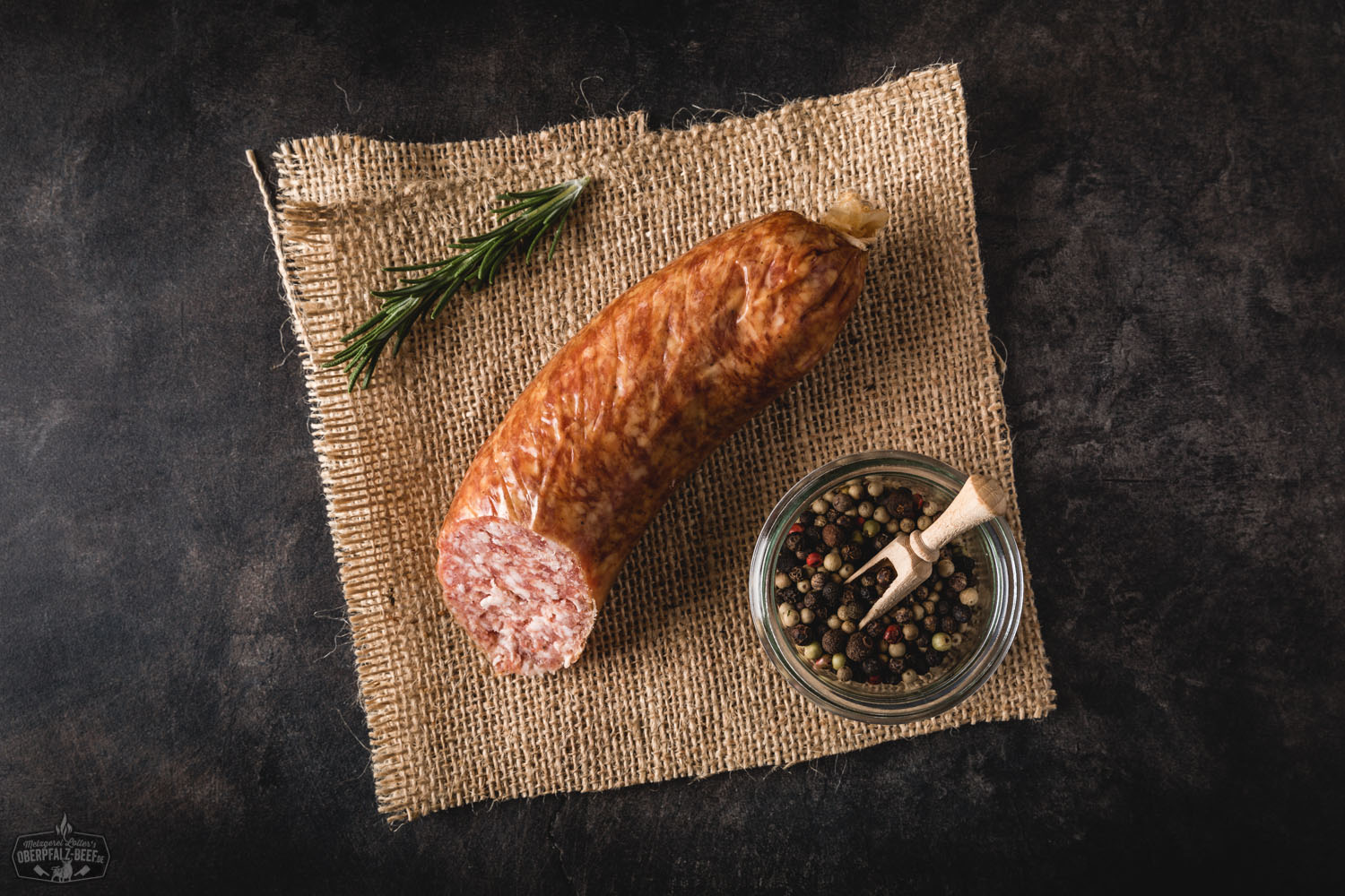 Grobe Mettwurst Portion – Hausgemachte Rohwurst aus Schweinefleisch Grobe Mettwurst in Portionsgröße, aufgeschnittene Wurst mit sichtbarer grober Fleischstruktur, serviert auf einem Holzbrett mit Petersiliengarnitur – traditionelle Räucherwurst aus der Oberpfalz.
