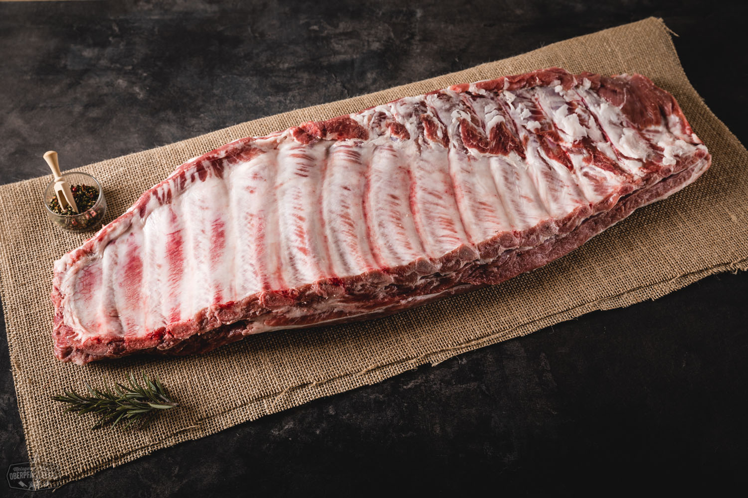 Saftige, goldbraun gegrillte St. Louis Style Ribs vom Oberpfälzer Landschwein auf einem Holzbrett angerichtet, mit knuspriger Kruste, saftiger Fleischstruktur und rauchigen Grillmarkierungen – perfekte BBQ-Rippchen für echte Fleischliebhaber.