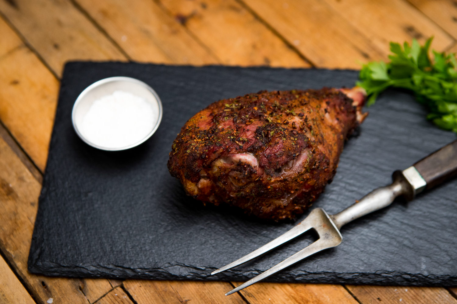 Unterkeulen vom Oberpfälzer Bauernhähnchen frisch und regional kaufen Rohe Hähnchen-Drumsticks vom Oberpfälzer Bauernhähnchen liegen auf einem dunklen Brett, umgeben von frischen Kräutern, Gemüse und Gewürzen; hochwertiges, regionales Geflügelfleisch für gesundes, nachhaltiges Kochen.