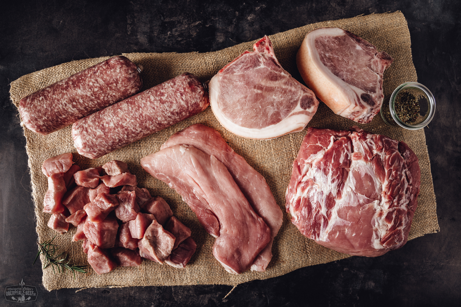 Frische Bauernhofbox mit Schweinefleisch direkt vom Erzeuger aus der Oberpfalz Frisch verpacktes Schweinefleisch aus artgerechter Haltung in einer offenen Bauernhof-Box auf Holztisch, mit regionalem Qualitätsfleisch, etikettierten Stücken und natürlichem Hintergrund – ideal für nachhaltigen Fleischgenuss.