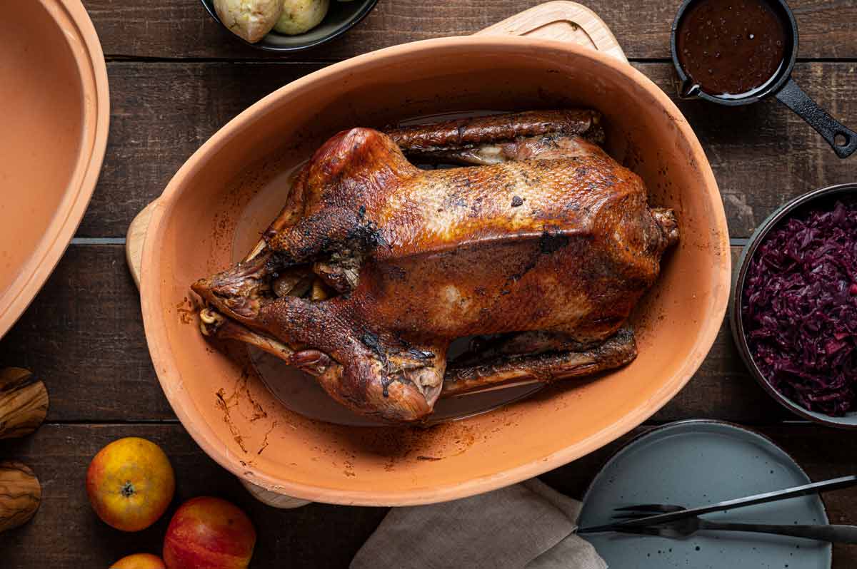 Knusprig gebratene Martinsgans mit Beilagen – festliches Gänseessen zu St. Martin Nahaufnahme einer Currywurst mit goldbrauner Bratwurst in dicker, glänzender Currysoße, angerichtet auf weißem Teller mit Currypulver bestreut – klassische deutsche Imbiss-Spezialität.