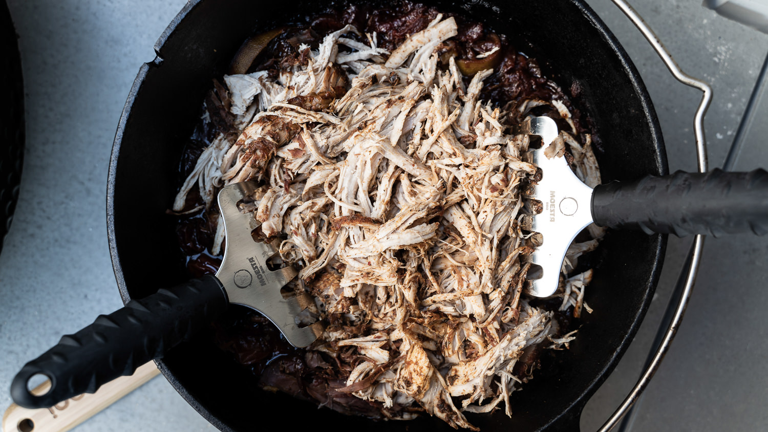 Pulled Chicken Burger mit Barbecue-Sauce und Cole Slaw auf Holzbrett Pulled Chicken serviert auf einem rustikalen Holzbrett, umgeben von saftigem Grün und einer Auswahl an Gemüse. Ideal für BBQ- und Grillfreunde, die nach köstlichen Rezepten und Inspiration für Pulled Chicken suchen.