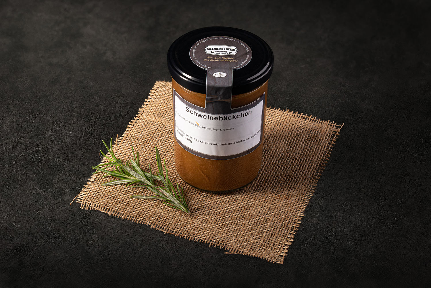 Ein Glaskonserviertes Schweinebacken-Gericht von Oberpfalz Beef auf einem rustikalen Holztisch mit Kräutern garniert, hochwertiges Fleischprodukt in nachhaltiger Verpackung.