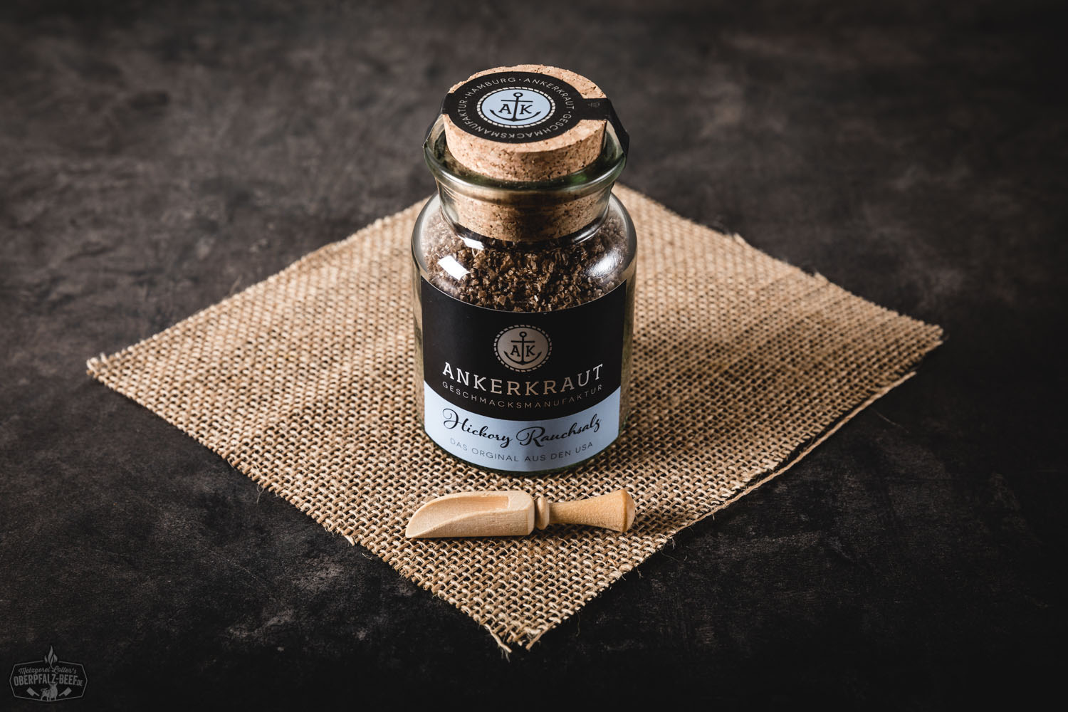 Hickory Rauchsalz von Ankerkraut in dekorativem Glas mit Korkverschluss, gefüllt mit grobkörnigem, braunem Räuchersalz vor weißem Hintergrund – BBQ-Gewürz für Grillen und Fleischgerichte.