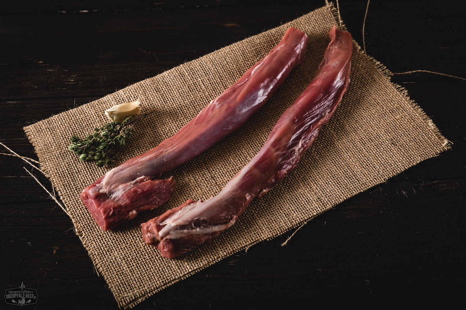 Zart gegrilltes Lammfilet vom Juradistl-Lamm auf dunklem Teller angerichtet, serviert mit Rosmarinzweig, grobem Meersalz und Grillgemüse – hochwertige Fleischspezialität aus der Oberpfalz.