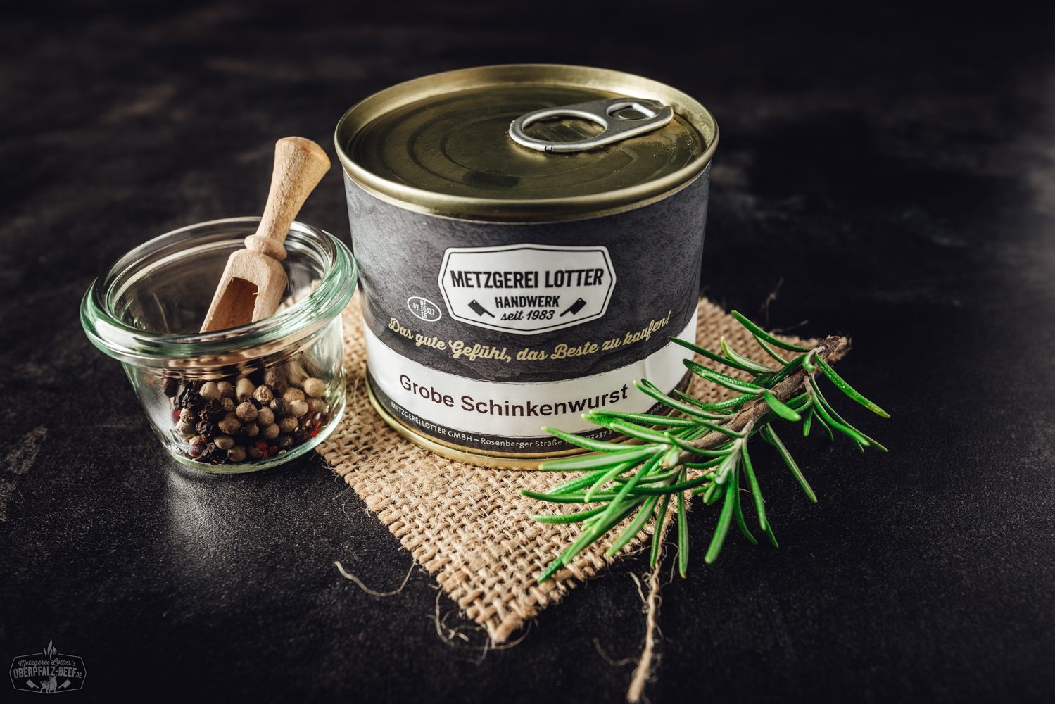 Ein Bild von einer groben Schinkenwurst in einer Dose, präsentiert auf einer natürlichen Holzoberfläche mit einem klaren, appetitlichen Aussehen.