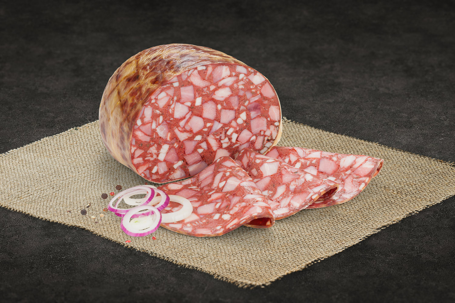 Geschnittene Rotwurst auf Holzbrett – Hausgemachte Spezialität aus der Oberpfalz Großes Stück Lachsschinken aus dem Schweinerücken auf Holzbrett, mager mit feiner Marmorierung, angeschnitten, daneben frische Kräuter und Gewürze – hochwertiges Fleischprodukt aus regionaler Herstellung.