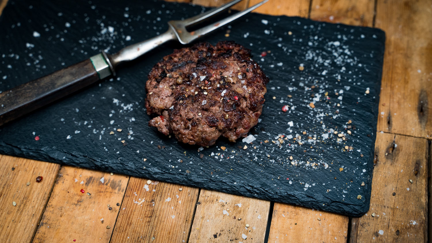 Dry Aged Burgerpatties vom Oberpfalz-Rind – Premium Rindfleisch für echten Genuss Fleisch für Dry Aged Burgerpatties vom Oberpfalz Rind, hochwertige Rindfleischstücke auf einem Holzbrett präsentiert, geeignet für Gourmet-Burgerliebhaber, frisches und regionales Produkt.