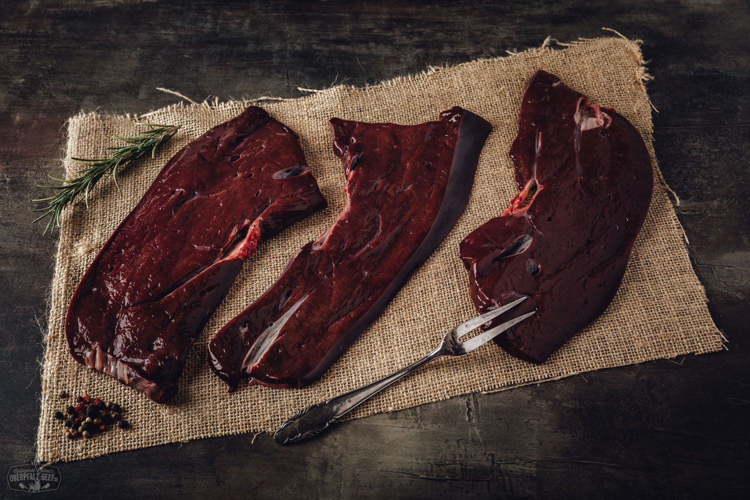 Roh geschnittene Rinderleber vom Oberpfalz-Rind auf dunklem Untergrund, frisch, saftig und tiefrot, angerichtet nebeneinander mit sichtbarer Faserstruktur – hochwertiges regionales Rindfleisch für bewusste Fleischliebhaber.