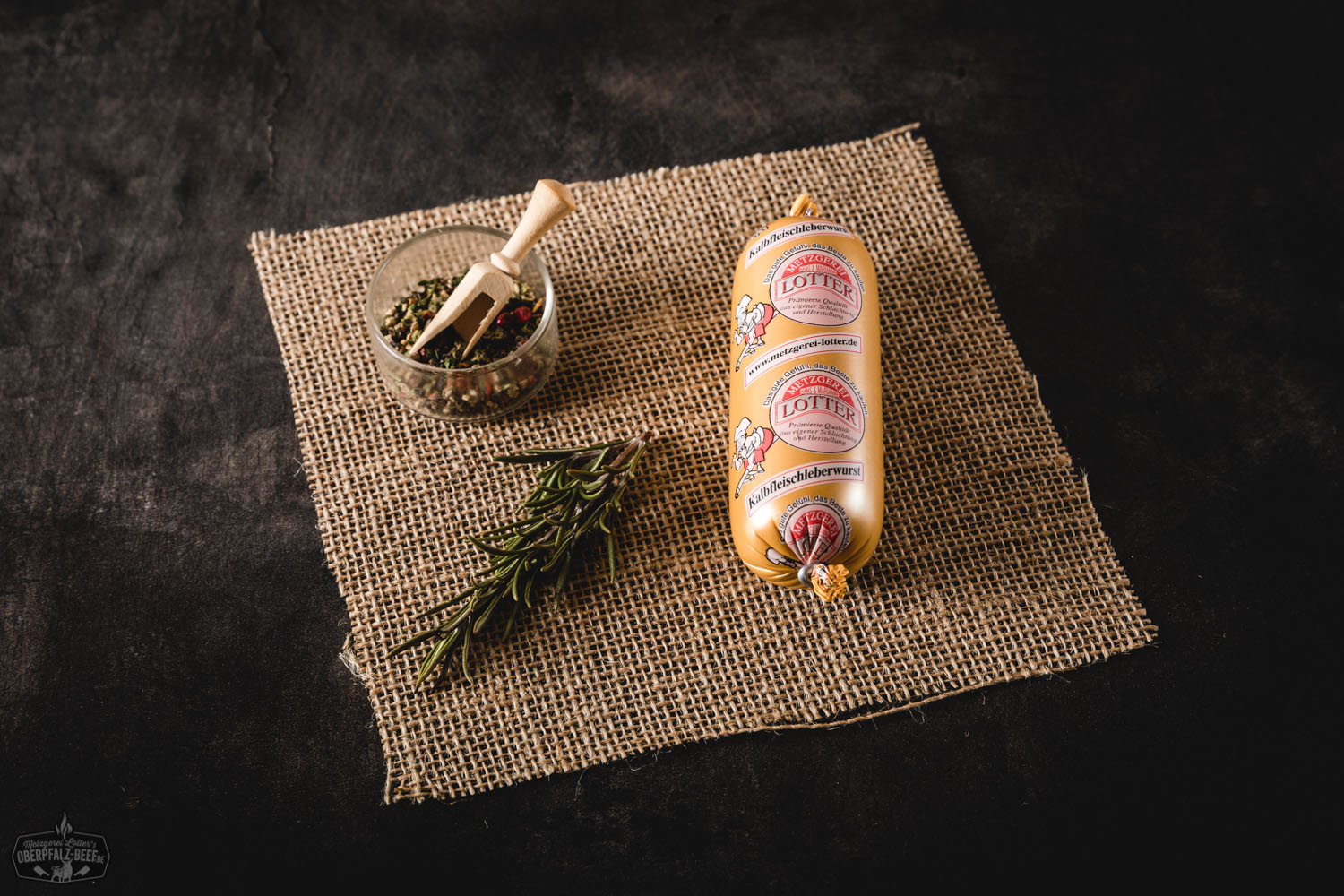 Kalbsleberwurst in Mini-Gläsern auf Holzunterlage, Vordergrund zeigt geöffnetes Glas mit cremiger Leberwurst, dekoriert mit frischem Brot, Zwiebeln und Petersilie – hochwertige Kalbfleisch-Leberwurst aus der Oberpfalz, traditionell hergestellt.